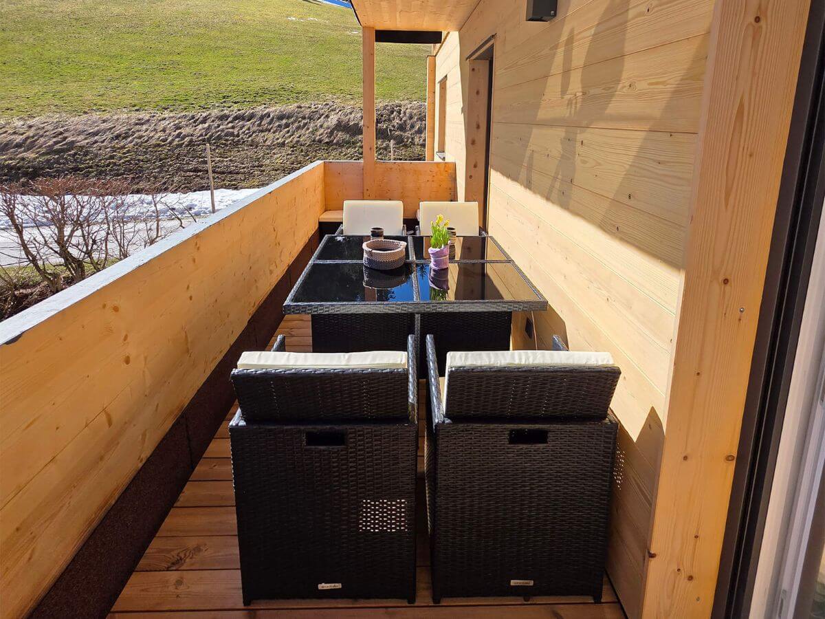 Zwei komfortable Sonnenstühle auf dem Holzbalkon des Alpinapartments Unterdürmoos, ideal zum Sonnenbaden mit Blick auf das Bergpanorama.