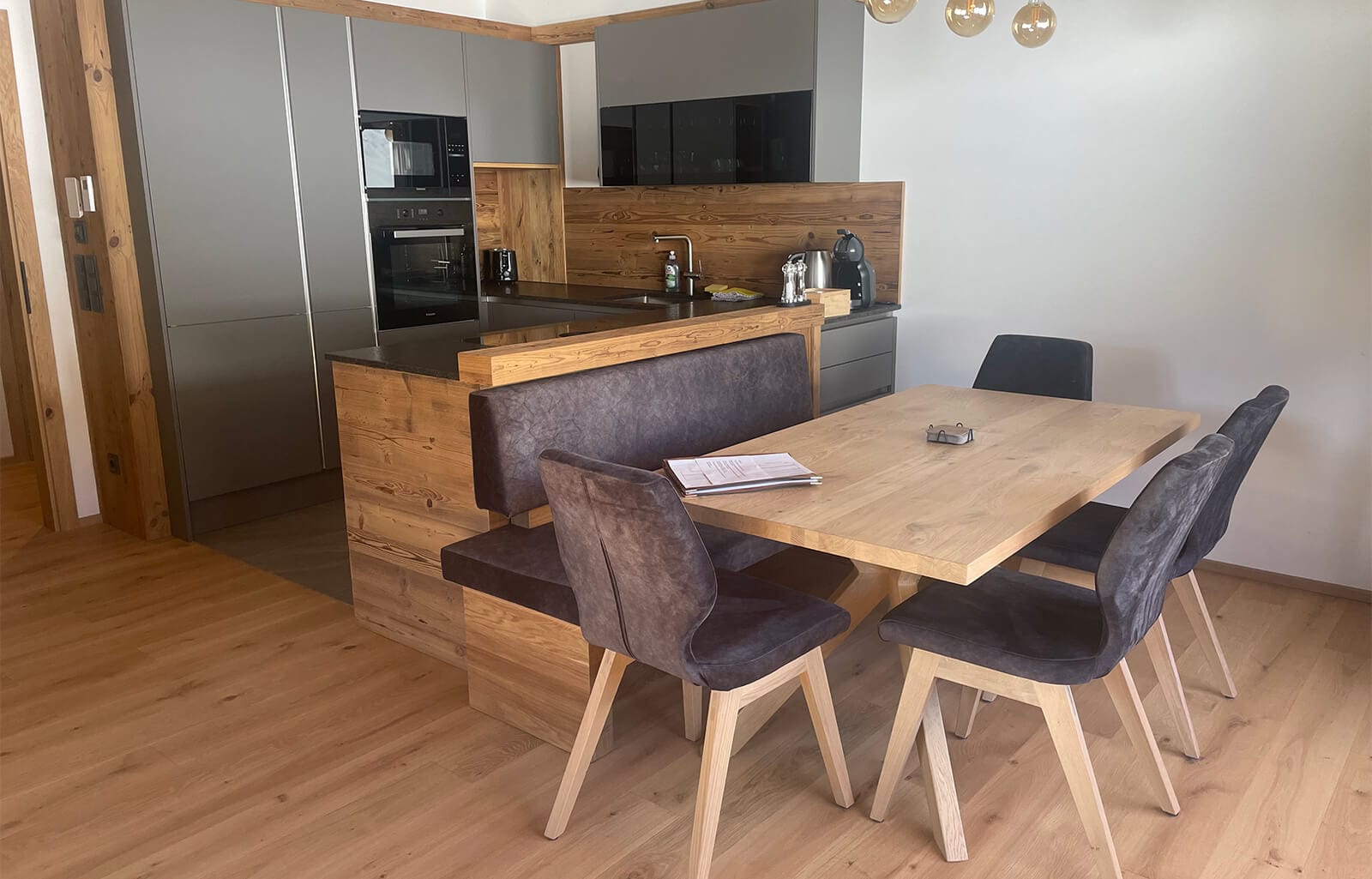 Großzügiger Essbereich im Apartment Bischofsmütze mit massivem Holztisch, zahlreichen Sitzplätzen und modernen Design-Stühlen für große Familien oder Gruppen.